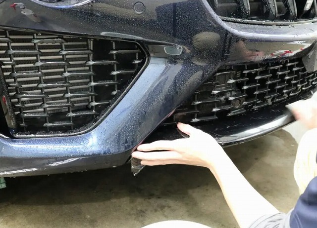 フロントバンパーにプロテクションフィルムを貼っている様子
