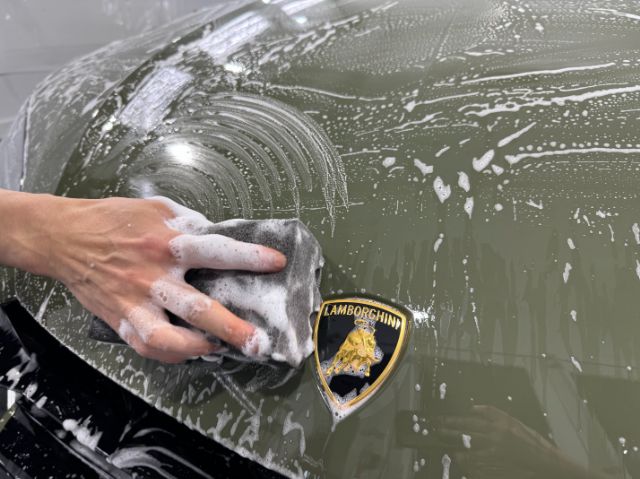 ランボルギーニウルスSE　ボンネットに熟練スタッフによる丁寧な洗車作業
