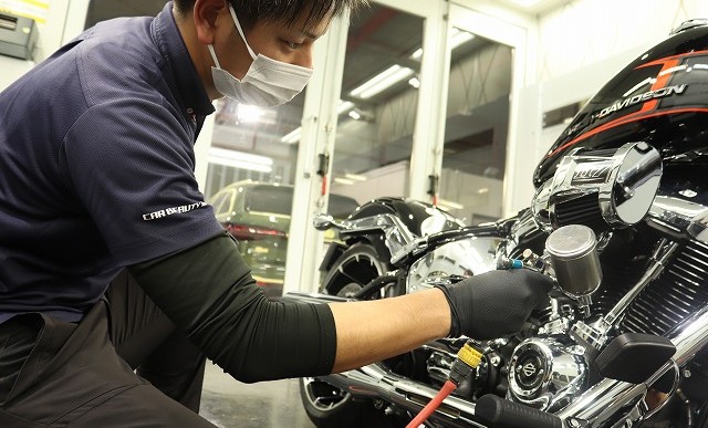 ガンスプレーで細かい隙間までしっかりコーティング剤を吹きかける様子