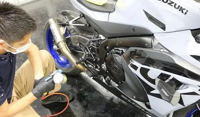 エンジン周辺にガンスプレーでコーティングする様子