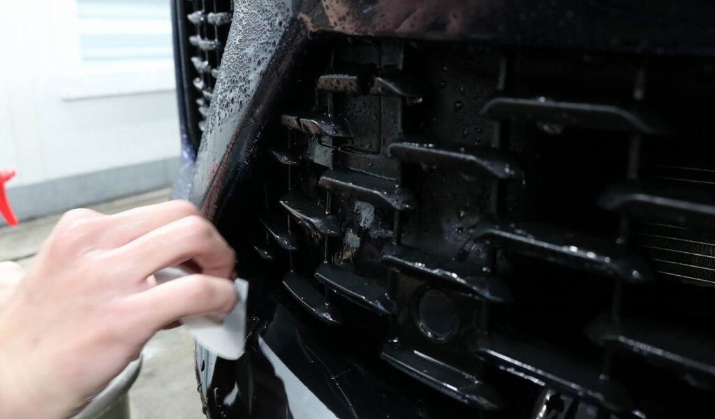 グリル・バンパー周辺にプロテクションフィルムを貼る様子