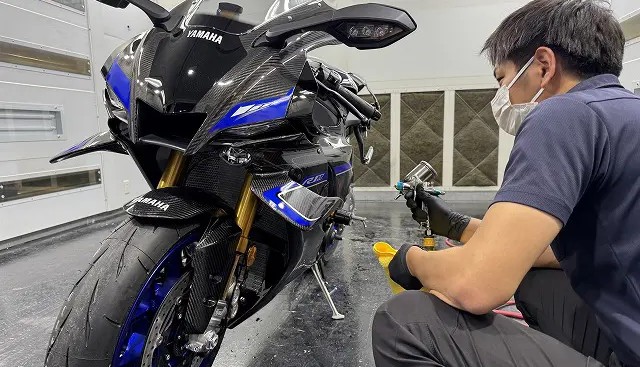 ガンスプレーでコーティング剤を吹き付けている様子