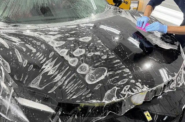 ボンネット部分にフィルムを貼っている様子