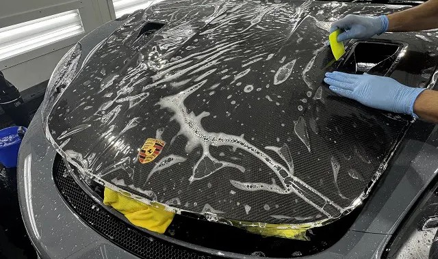 ポルシェのボンネットにプロテクションフィルムを貼っている様子