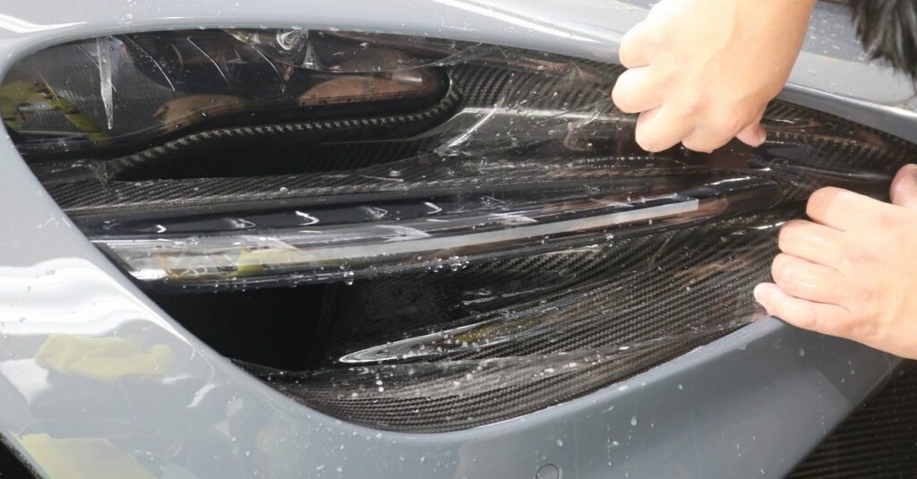 ヘッドライト周辺にプロテクションフィルムを貼っている様子