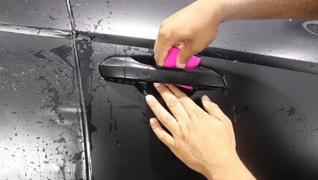 ドアカップ部分にプロテクションフィルムを施工する様子