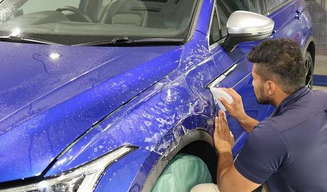 フォルクスワーゲンティグアンのフロントフェンダーにプロテクションフィルムを貼っている様子