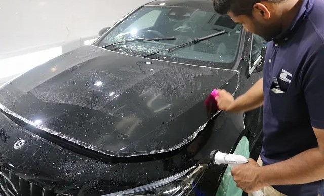 ベンツのボンネット部分にプロテクションフィルムを貼る様子