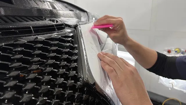 レクサスLCのグリル部分にフィルムを貼っている様子