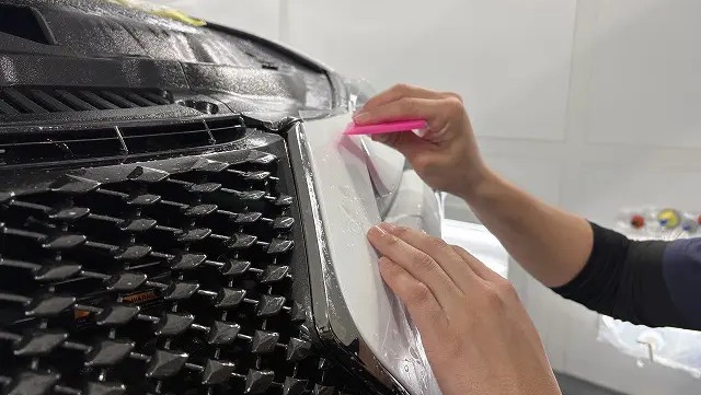レクサスLC500のグリル周辺にプロテクションフィルムを貼っている様子